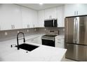 Well-lit kitchen with white cabinetry, stainless steel appliances, and updated countertops at 240 W Palmetto Ave, Deland, FL 32720
