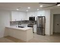Modern kitchen featuring white cabinets, stainless steel appliances, and marble countertops at 240 W Palmetto Ave, Deland, FL 32720