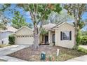 Inviting single-story home with a two-car garage, lush trees, and well-maintained front yard at 2468 Cimmaron Ash Way, Apopka, FL 32703
