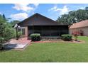 Backyard featuring a screened-in porch and meticulously maintained landscaping at 2656 Whisper Lakes Club Cir, Orlando, FL 32837