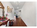 Elegant hallway featuring dark hardwood floors, a chandelier, and tasteful decorations at 2723 Forestdale St, St Cloud, FL 34771