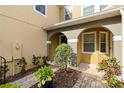 Covered front entrance featuring arched openings, manicured landscaping, and a brick-paved walkway at 2829 Shady Willow Ln, Oviedo, FL 32765