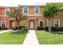 Charming townhouse exterior boasts a tile roof, lush lawn, and attractive landscaping features at 3069 White Orchid Rd, Kissimmee, FL 34747