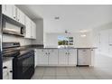 Bright kitchen boasts white cabinetry, black appliances, granite countertops, and an eat-in bar at 312 Arbor Lakes Dr, Davenport, FL 33896