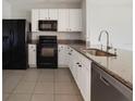 Well-appointed kitchen featuring granite countertops, stainless steel appliances, and tile flooring at 312 Arbor Lakes Dr, Davenport, FL 33896