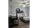 Inviting bedroom featuring modern ceiling fan, wood floors, Mickey Mouse decor and neutral colors at 3193 Yellow Lantana Ln, Kissimmee, FL 34747
