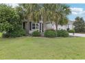 Attractive single-story home with a lush green lawn and mature landscaping at 3198 Abana Path, The Villages, FL 32163
