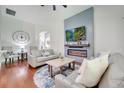 Elegant living room with a fireplace and large screen TV feature wall, hardwood floors and comfortable seating at 3380 Pawleys N Loop, St Cloud, FL 34769
