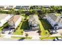 Aerial view of a home with a green lawn, surrounded by well-maintained landscaping and neighboring houses at 341 Falls Dr, Kissimmee, FL 34747