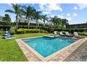 Inviting pool with a hot tub, surrounded by lounge chairs, lush landscaping, and tall palm trees at 341 Falls Dr, Kissimmee, FL 34747