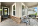 Inviting front porch features brick flooring, stone accents and comfortable seating area at 488 Kistler Cir, Clermont, FL 34715