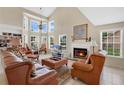 Bright living room with high ceilings, a fireplace, and lots of natural light from large windows at 518 Glen Grove Ln, Orlando, FL 32839