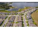 Aerial view of modern townhome community near a scenic lake and lush greenery at 6132 Bimini Twist Loop, Orlando, FL 32819
