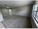 Spacious living room featuring neutral carpet, a large window and decorative trim at 6624 Kristin Ct, Orlando, FL 32818