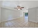 A neutral-toned living space with tiled flooring and an open layout leading to a pool view at 7614 Sw 80Th St, Ocala, FL 34476