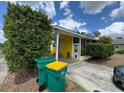 Charming home featuring a covered porch, yellow siding, and two green trash cans at 825 Poinsettia Dr, Eustis, FL 32726