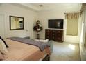 Spacious bedroom with a TV on dresser, plush carpet, and natural light from the window at 9005 Reflection Pointe Dr, Windermere, FL 34786