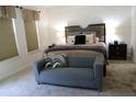 Cozy bedroom featuring a sitting area and a comfortable bed with stylish pillows and a padded headboard at 9005 Reflection Pointe Dr, Windermere, FL 34786
