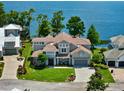 Stunning aerial view of an upscale home with a tile roof, lush lawn, and waterfront access on a sunny day at 9916 Lone Tree Ln, Orlando, FL 32836