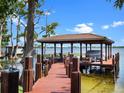 Picturesque wooden dock with a covered boat lift offers tranquil waterfront access to a serene lake and boat house at 9916 Lone Tree Ln, Orlando, FL 32836