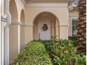 Charming front entry features an arched doorway, decorative wreath, and lush landscaping at 10371 Kensington Shore Dr # H-201, Orlando, FL 32827