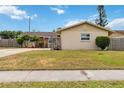 Single-story home with tan siding and manicured lawn in a sunny day with partial stone facade and a well manicured front yard at 10934 Tangora St, Orlando, FL 32825