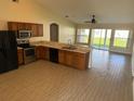 Open kitchen featuring stainless steel appliances, tile floors, light countertops, and wood cabinets at 1115 Fidelma Ct, Orlando, FL 32824