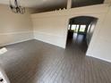 Spacious living room featuring tile flooring, neutral walls, an arched entryway, and contemporary lighting at 1115 Fidelma Ct, Orlando, FL 32824
