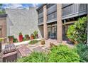 A ground-level exterior shot showcasing a townhouse entrance with a small patio and colorful potted plants at 1130 Washington Ave # 11, Winter Park, FL 32789