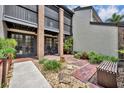 A close exterior shot featuring a townhouse entrance with red brick, a small patio, and manicured greenery at 1130 Washington Ave # 11, Winter Park, FL 32789