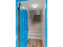 Entryway featuring wood floors, carpeted stairs, and blue door at 1210 Maury Rd # 3, Orlando, FL 32804