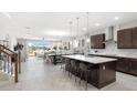 Modern open-concept kitchen features a large island, pendant lighting, and contemporary finishes at 12966 Promise Pl, Orlando, FL 32832
