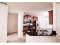 Well-appointed kitchen with dark cabinets, granite counters, and stainless steel appliances at 145 Palazzo Ln, Kissimmee, FL 34759