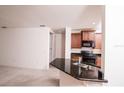 Modern kitchen features dark wood cabinetry, granite countertops, and stainless steel appliances at 145 Palazzo Ln, Kissimmee, FL 34759