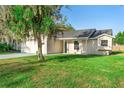 Charming single-story home with a well-maintained lawn, mature tree, and two-car garage at 1550 Maxwell Ln, Deltona, FL 32738