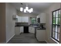 Bright kitchen features white cabinets, granite countertops, and stainless steel appliances at 1550 Maxwell Ln, Deltona, FL 32738