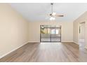 Open living room with wood-look floors and sliding doors to an enclosed lanai at 1550 Maxwell Ln, Deltona, FL 32738