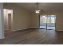 Open living room with modern flooring, ceiling fan, and access to screened patio at 1550 Maxwell Ln, Deltona, FL 32738