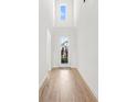 Bright foyer with high ceilings, wood floors, and a clear view to the front door with sidelights at 16124 Volterra Pt, Montverde, FL 34756