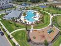 Aerial view of community pool, playground, and surrounding homes in a Primary-planned neighborhood at 16436 Parable Way, Winter Garden, FL 34787