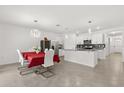 Bright and modern kitchen features white cabinets, stainless steel appliances, granite counters, and an island with pendant lighting at 1693 Barberry Dr, Kissimmee, FL 34744
