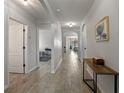 Bright hallway featuring wood-look flooring and an open view of the home's living spaces at 1836 Partin Terrace Rd, Kissimmee, FL 34744