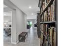 Hallway with tiled floor, adjacent to a bedroom and a built in bookshelf along a wall at 208 Summerlin Ln, Haines City, FL 33844