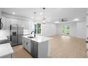 Bright kitchen with stainless steel appliances, modern island, and an open view to the light-filled living space at 2131 Brighton Ln, Orlando, FL 32817