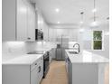 Modern kitchen with white cabinets, stainless steel appliances, quartz countertops, and an island with a sink at 2131 Brighton Ln, Orlando, FL 32817