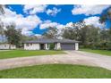 Lovely single-story home with a well-manicured lawn, gray roof, a paved driveway, and a two-car garage at 237 Church St, Lake Helen, FL 32744