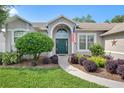 Attractive home entrance framed by landscaping featuring a curved walkway leading to an arched doorway at 249 Mill Slough Rd, Oviedo, FL 32766