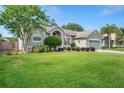 Charming exterior displaying a lush green lawn, mature trees, and a lovely walkway to the front door at 249 Mill Slough Rd, Oviedo, FL 32766
