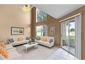 Bright living room featuring high ceilings, neutral walls, and a sliding glass door to the screened patio at 2498 Saint Augustine Blvd, Haines City, FL 33844