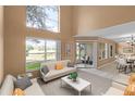 Bright living room featuring high ceilings, neutral walls, and a sliding glass door to the screened patio at 2498 Saint Augustine Blvd, Haines City, FL 33844